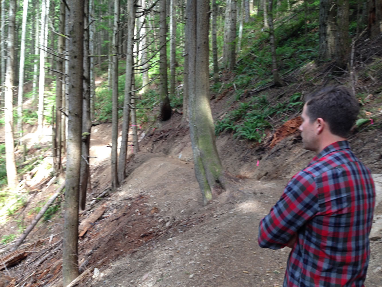 In this Aug. 28, 2015, photo, Sam Jarrett with the Washington Department of Natural Resources checks on a section of the Tiger Mountain State Forest biking trail near Issaquah, Wash. The Washington Department of Natural Resources says the new trail should open in springtime.