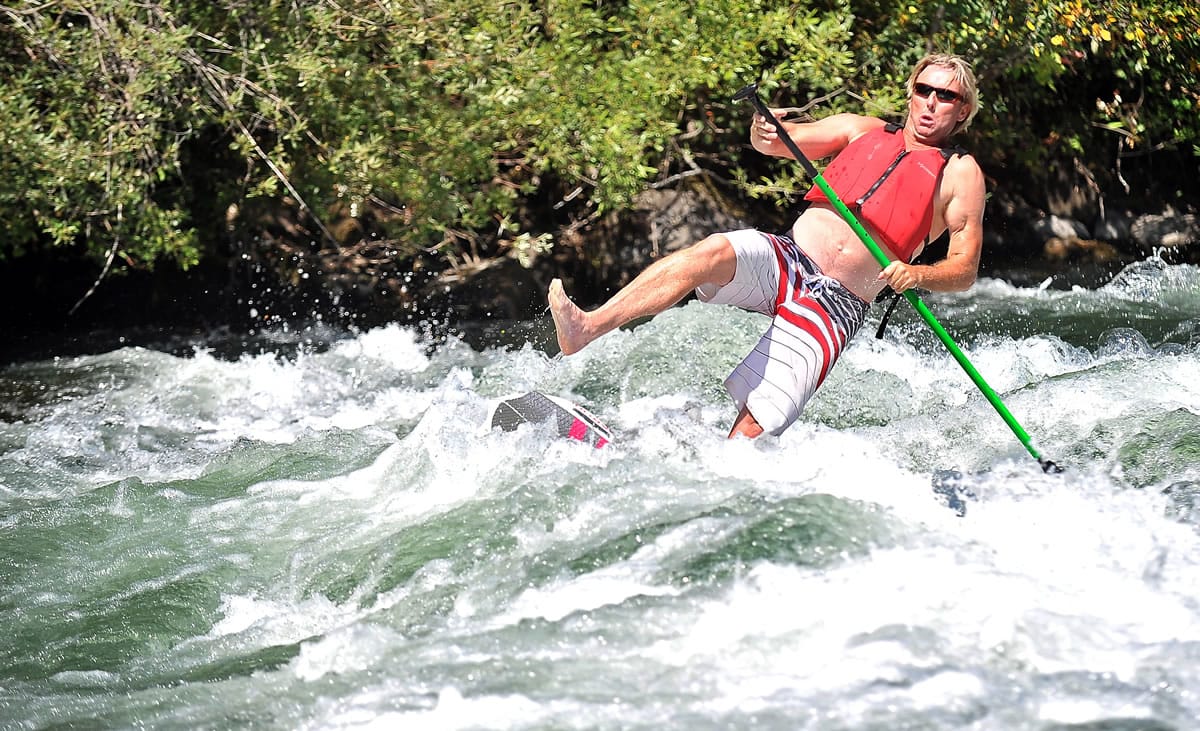 Photos by Jamie Lusch/The Medford Mail Tribune
Devon Stephenson, owner of Rapid Pleasure Rentals, takes a spill Aug. 26 from a stand-up paddleboard on the Rogue River near Shady Cove, Ore.