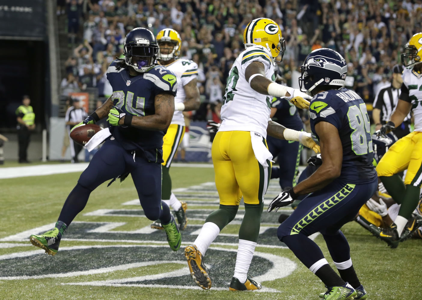 Seattle Seahawks running back Marshawn Lynch, left, looks back after a touchdown against the Green Bay Packers in the second half of an NFL football game, Thursday, Sept. 4, 2014, in Seattle.