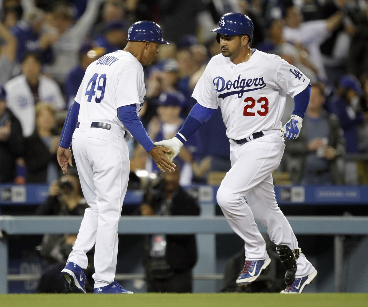 Los Angeles Dodgers third base coach Lorenzo Bundy, left, congratulates Adrian Gonzalez for hitting a solo home run during the third inning, his second of the game against the San Diego Padres in Los Angeles, Wednesday, April 8, 2015.