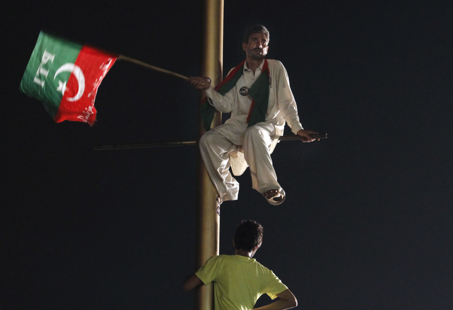 A supporter of Pakistan's cricketer-turned-politician Imran Khan climbs on a pole and listens to his leader's speech during a protest in Islamabad's high-security &quot;Red Zone,&quot; in Islamabad, Pakistan, on Wednesday.