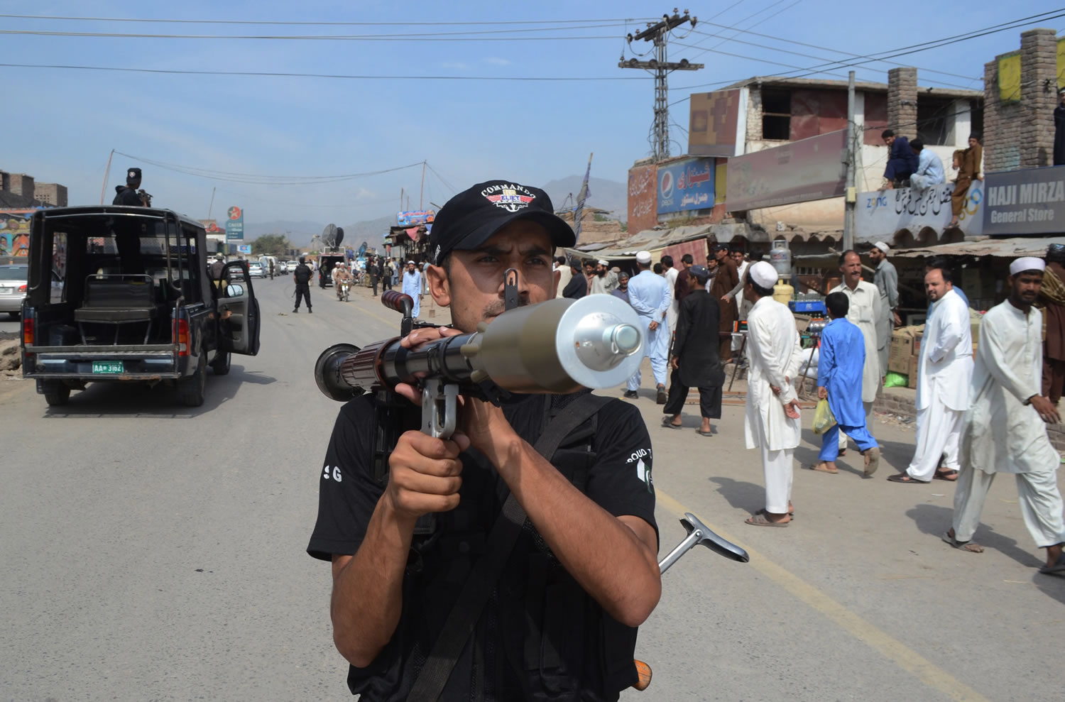 A Pakistani police commando stands guard near the scene where NATO trucks were attacked in the Pakistani tribal area of Jamrud near Peshawar, Pakistan, on Monday.