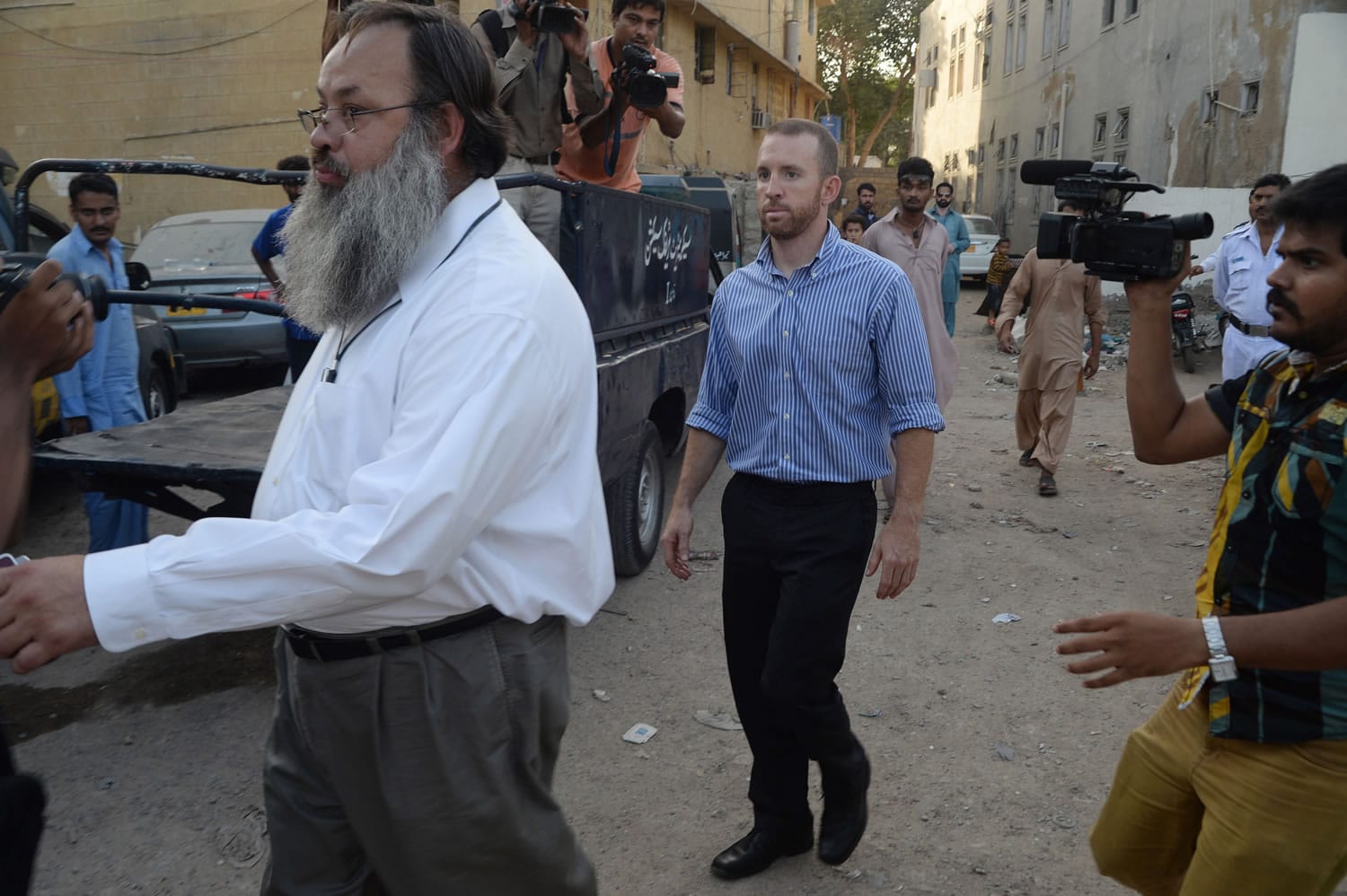 An American national, center, reportedly working for the FBI, leaves a police station in Karachi, Pakistan, on Thursday.