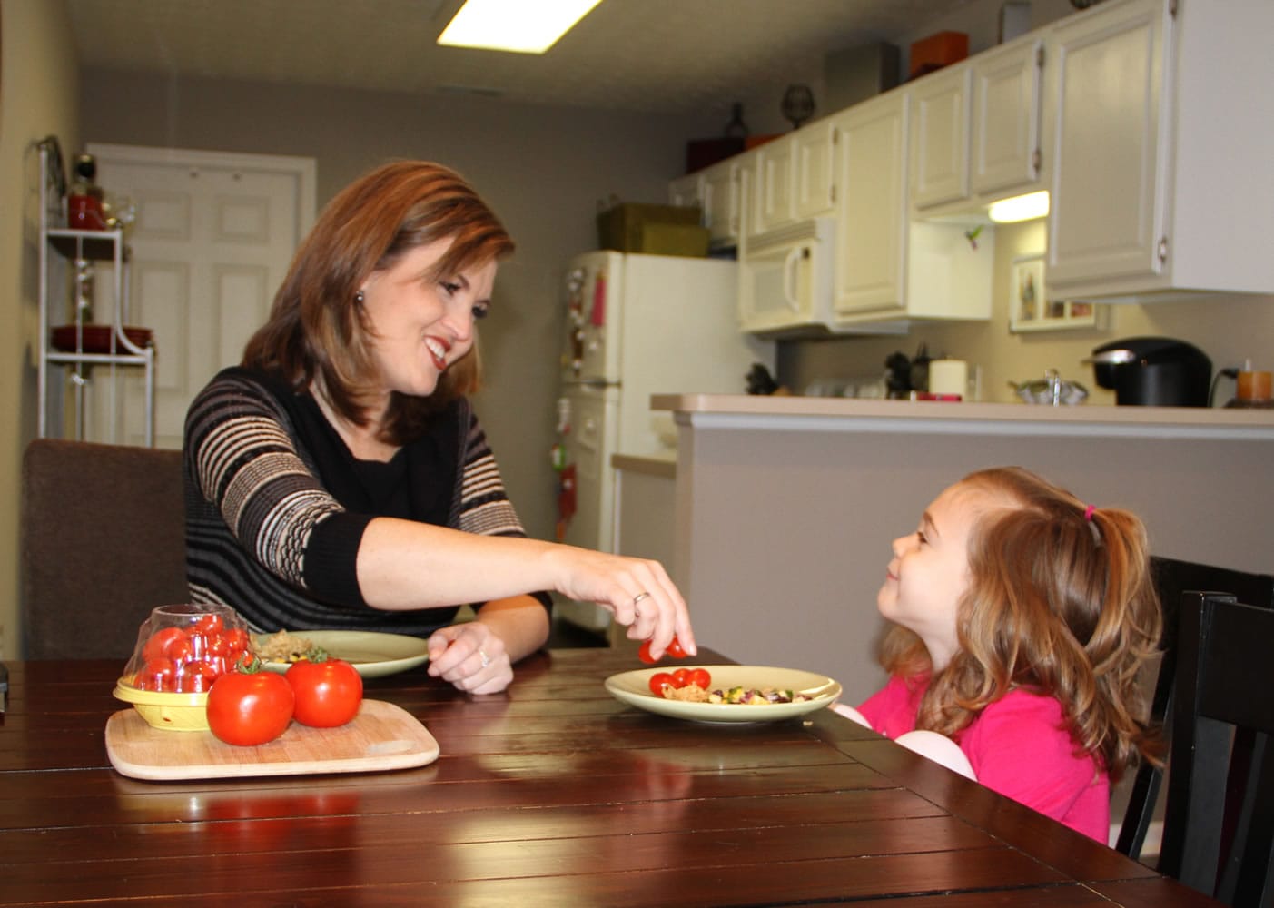 Shannon McCormick serves a tomato to her 4-year-old daughter, Sophie Chapman, at their home in Gahanna, Ohio.