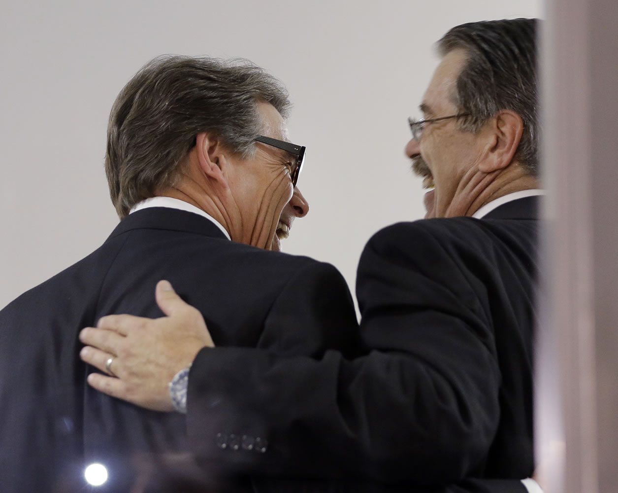 ERIC GAY/Associated Press
Texas Gov. Rick Perry, left, laughs with his attorney, David Botsford, as he is booked Tuesday at the Blackwell Thurman Criminal Justice Center in Austin, Texas, on two felony counts.