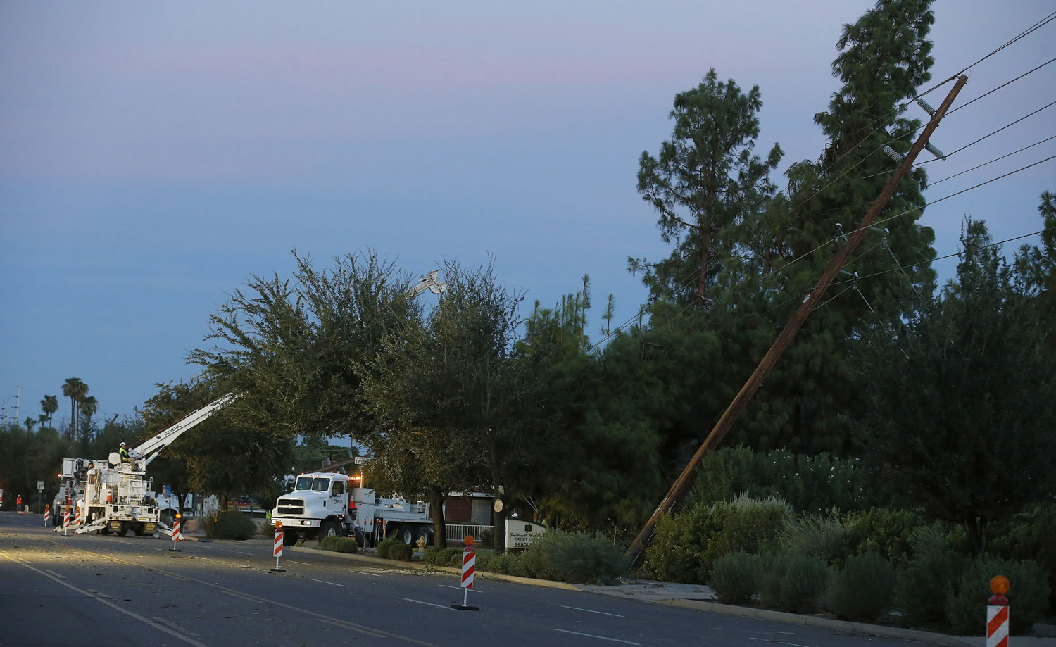 Power crews begin working on downed power lines to restore power to thousands left in the dark early on Tuesday in Phoenix, after monsoon storms hit the Phoenix area Monday night knocking out power to thousands, delaying air travel, and stranding motorists in flash floods.