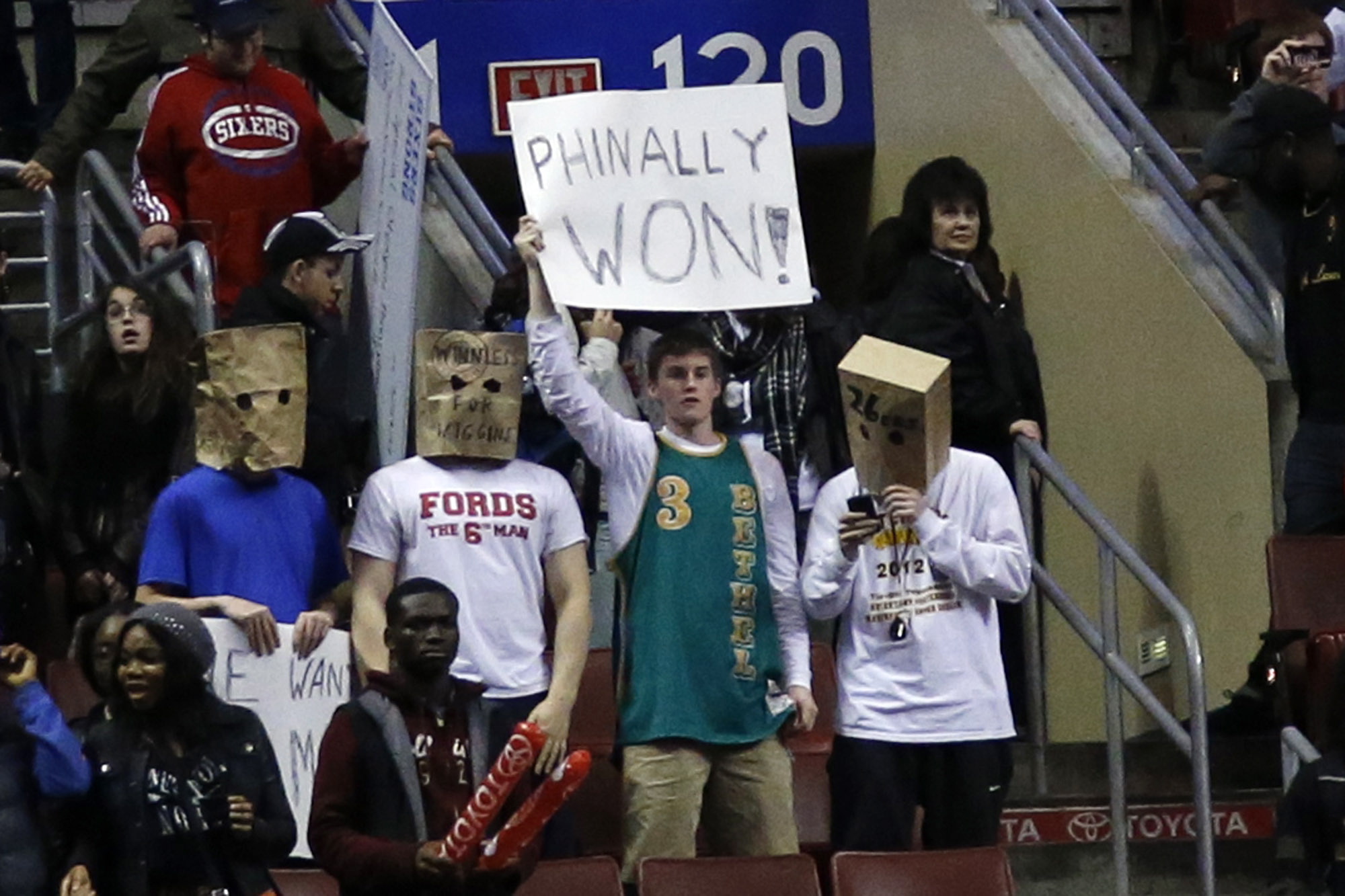 Fans hold signs after the Philadelphia 76ers won an NBA basketball game against the Detroit Pistons, Saturday, March 29, 2014, in Philadelphia. Philadelphia won 123-98, breaking a 26-game losing streak.