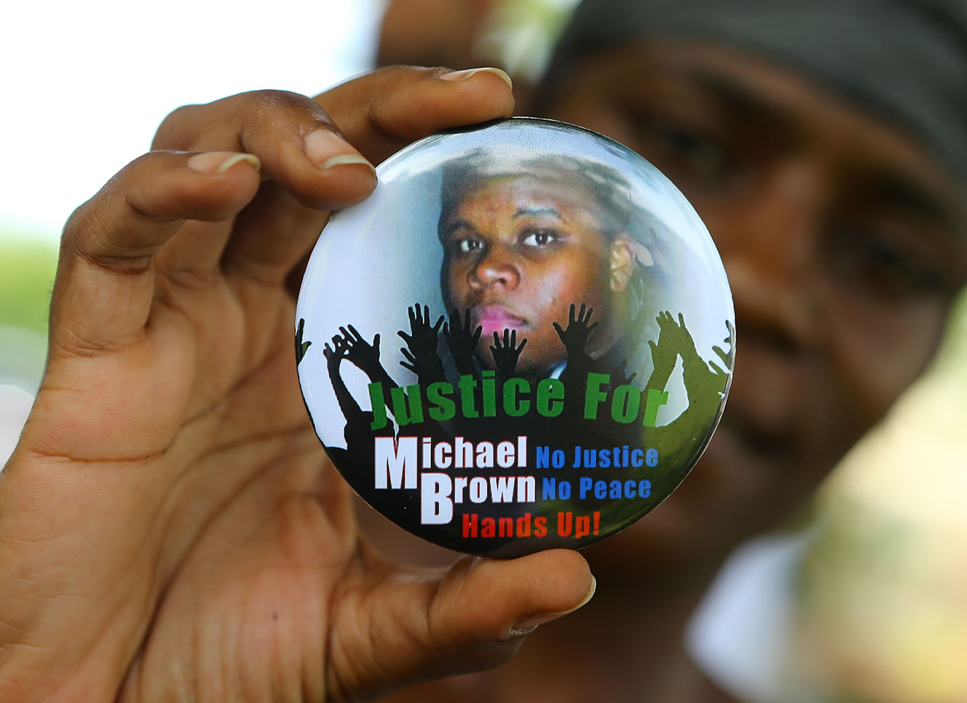 Curtis Compton/Atlanta Journal Constitution
Nikki Jones, of Spanish Lake, Mo, holds a button in support of Michael Brown while visiting where he was fatally shot by police in Ferguson.