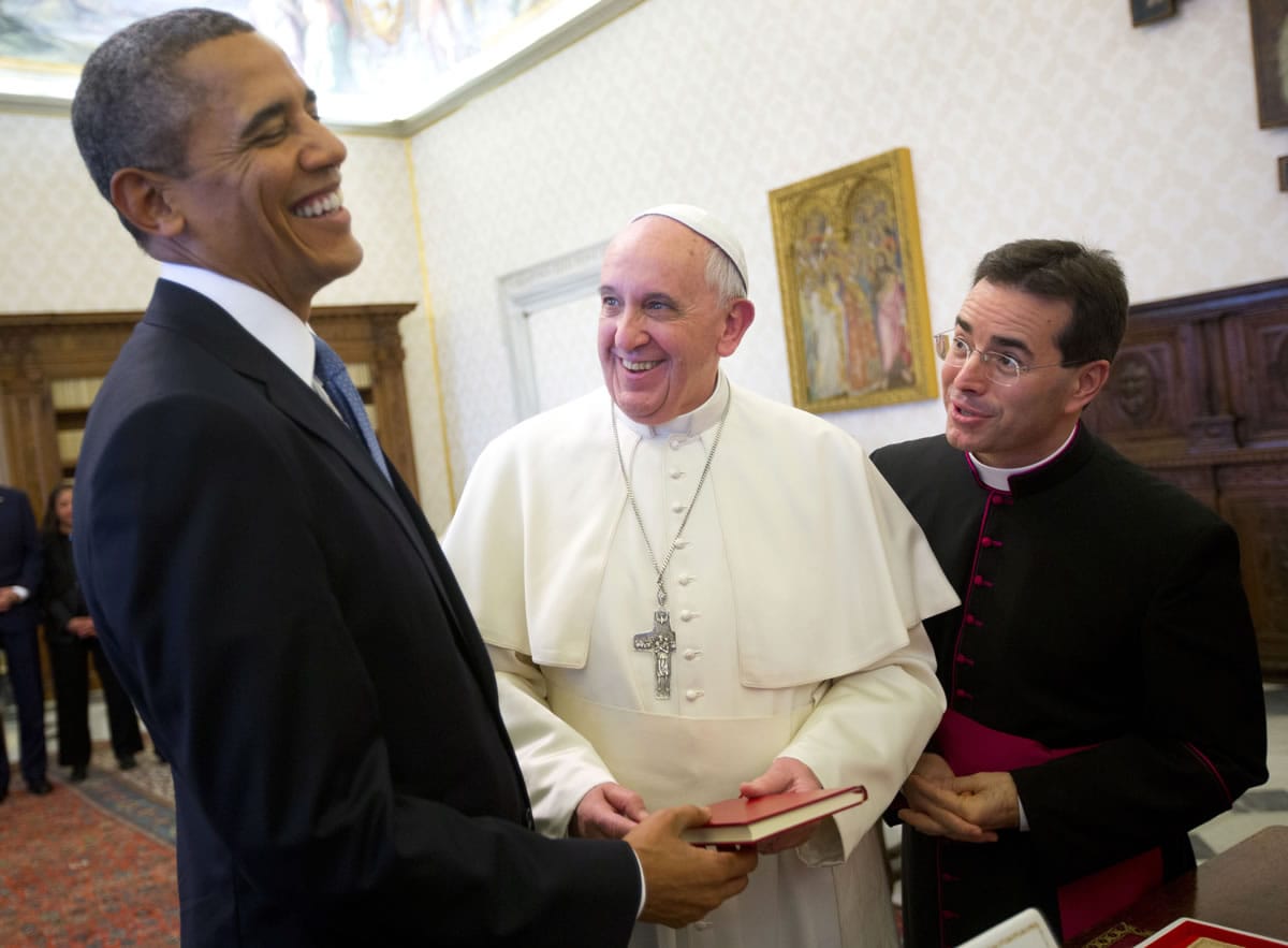 President Barack Obama, left, reacts as he meets with Pope Francis, center, during their exchange of gifts March 27, 2014 at the Vatican. Obama called himself a "great admirer" of Pope Francis as he sat down at the Vatican Thursday with the pontiff he considers a kindred spirit on issues of economic inequality. In September 2015, the pope's introduction to the U.S. will begin in Washington, where he will address a joint meeting of Congress, followed by an address to the U.N. General Assembly in New York, and outdoor Mass at the World Meeting of Families in Philadelphia. At right is Msgr.