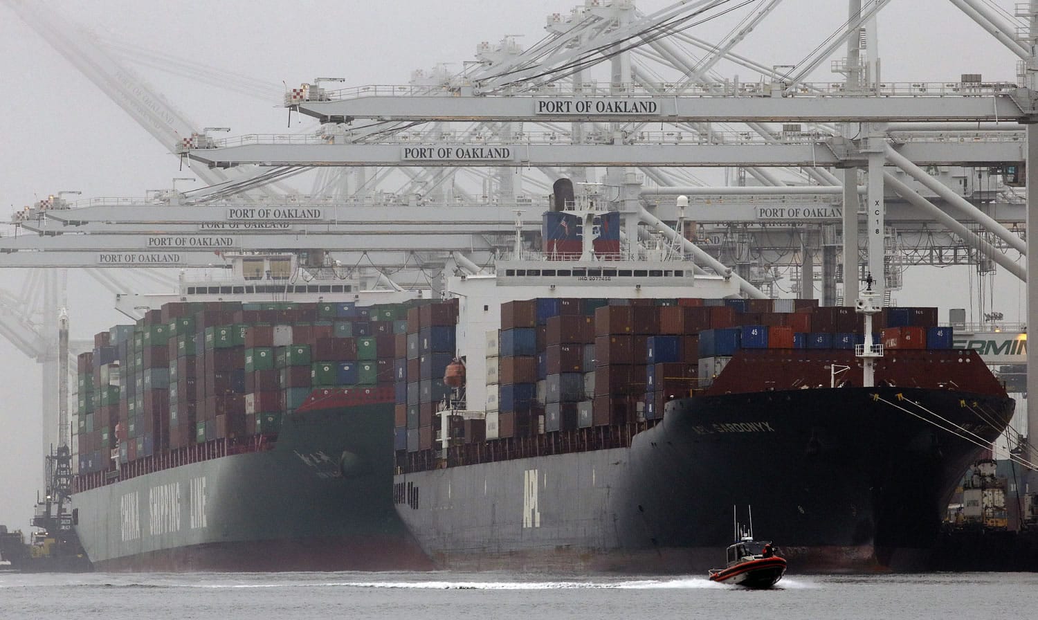 Container ships wait to be off-loaded at the Port of Oakland in Oakland, Calif. The West Coast ports that are Americais gateway for hundreds of billions of dollars of trade with Asia and beyond are no stranger to labor unrest and even violence.