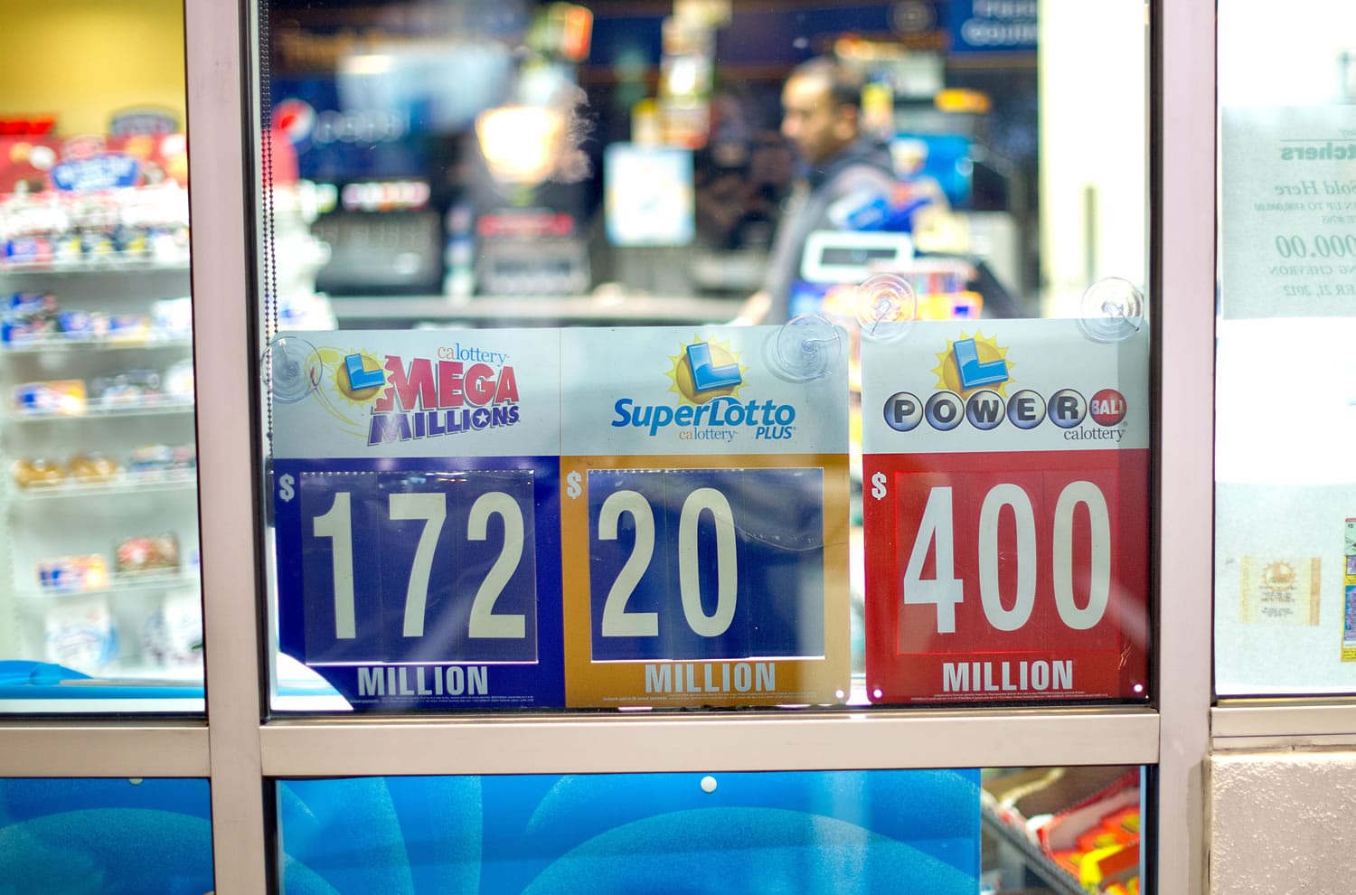 A night worker passes lottery signs at Dixon Landing Chevron in Milpitas, Calif., on Thursday.