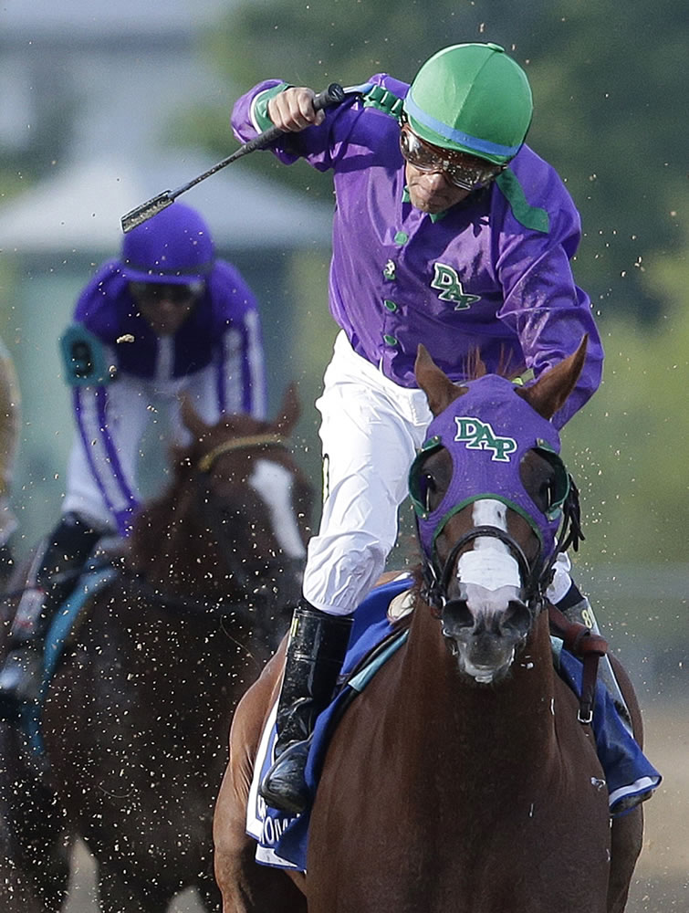 Jockey Victor Espinoza celebrates aboard California Chrome after winning the 139th Preakness Stakes horse race at Pimlico Race Course, Saturday, May 17, 2014, in Baltimore.