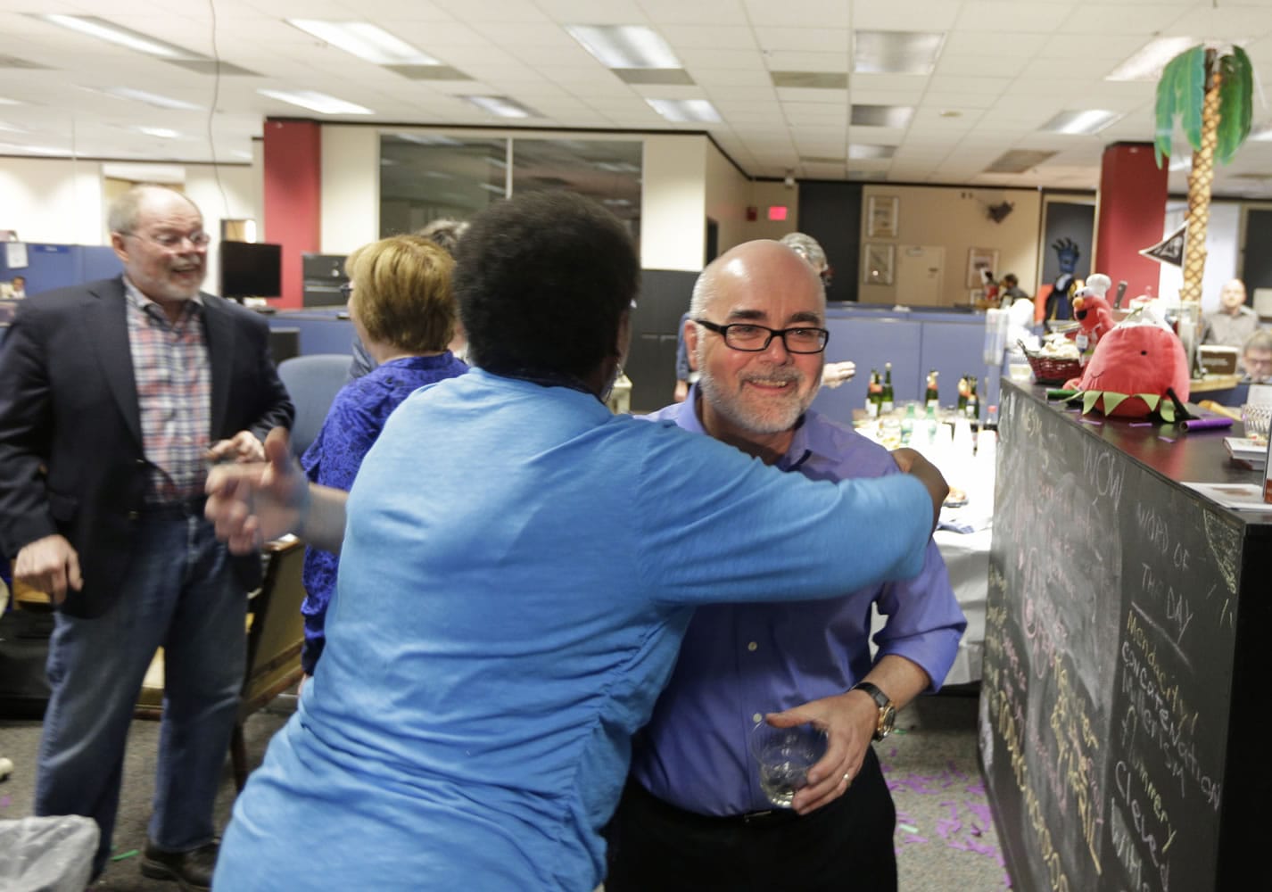 Charlotte Observer editorial cartoonist Kevin Siers, right, gets a hug from a co-worker as the newsroom celebrates Siers winning the Pulitzer Prize for Editorial Cartooning at the newspaper in Charlotte, N.C., on Monday.