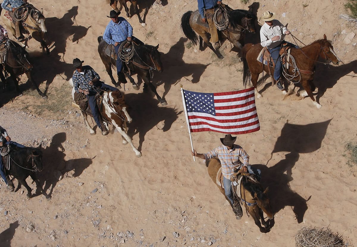 The Bundy family and their supporters fly the American flag as their cattle is released by the Bureau of Land Management back onto public land outside of Bunkerville, Nev., on April 12.