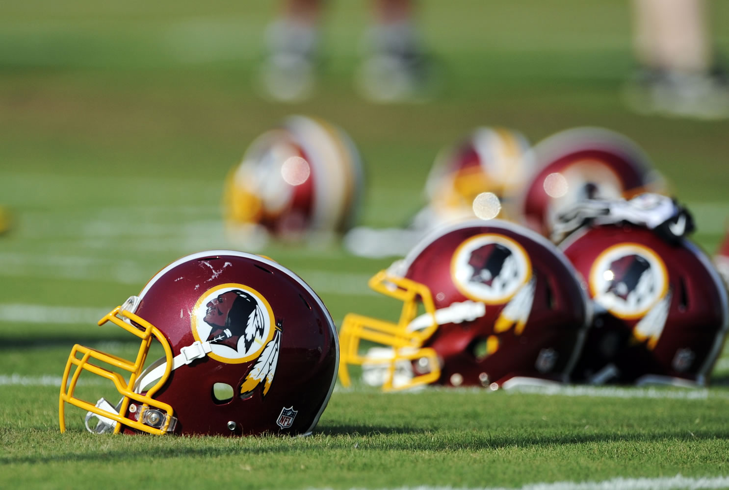 Washington Redskins helmets sit on the field during an NFL football minicamp in Ashburn, Va.