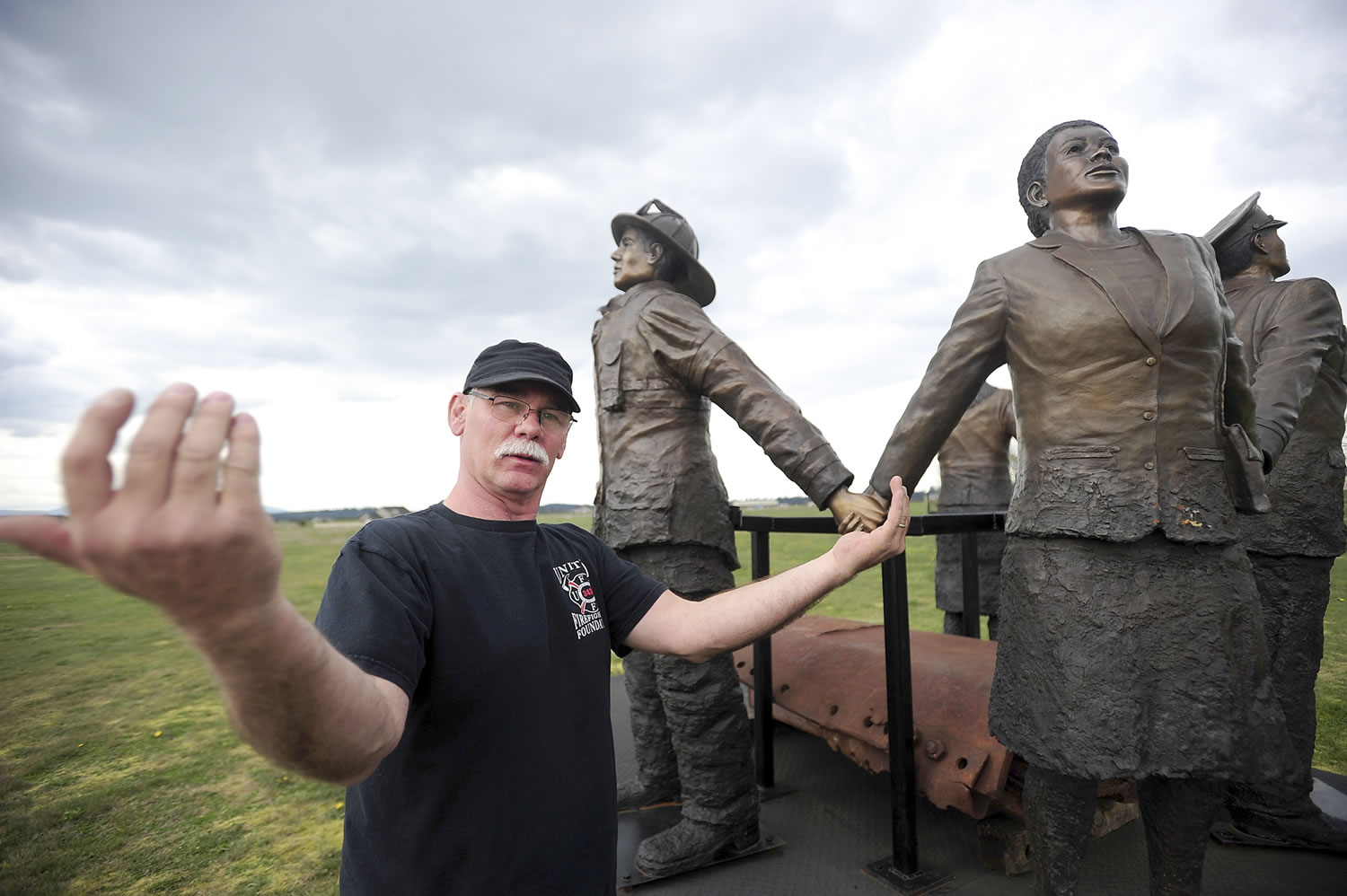 John Jackson explains the significance of statues holding hands in his 9/11 monument at his home in Tenino. Jackson, who worked with the Spirit of America Foundation, built the sculpture in honor of people affected by the Sept.