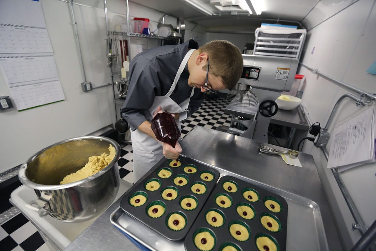 Chef Alex Tretter adds strawberry jam to cannabis-infused peanut butter and jelly cups before baking them Thursday at Sweet Grass Kitchen, a well-established gourmet marijuana edibles bakery which sells its confections to retail outlets, in Denver.