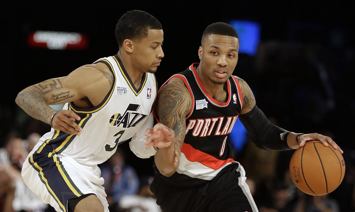 Team Hill's Damian Lillard of the Portland Trail Blazers, right, moves the ball against Team Webber's Trey Burke of the Utah Jazz during the Rising Star NBA All Star Challenge Basketball game, Friday, Feb. 14, 2014, in New Orleans.