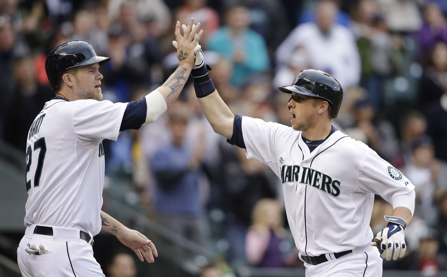 Seattle Mariners' Justin Smoak, right, is congratulated by Corey Hart as he crosses home on his two-run home run against the Kansas City Royals in the fourth inning Saturday.