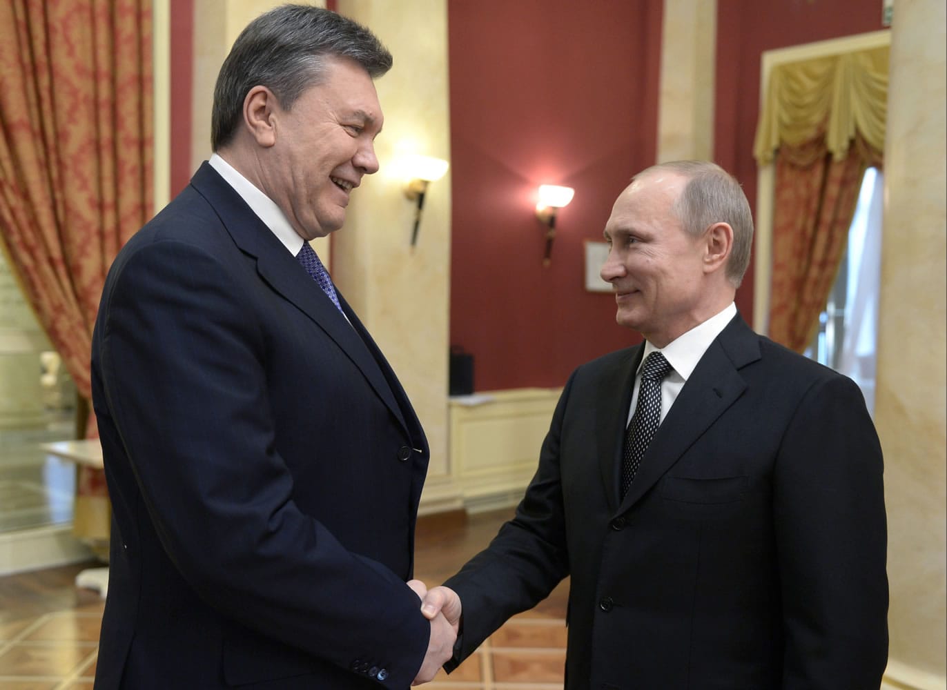 Russian President Vladimir Putin, right, shakes hands with Ukrainian President Viktor Yanukovych at the Olympic reception hosted by the Russian President in Sochi, Russia.