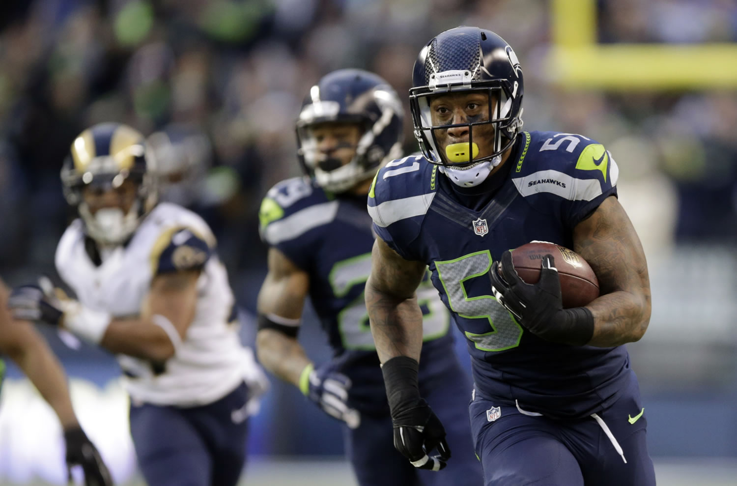 Seattle Seahawks linebacker Bruce Irvin, right, returns an interception for a touchdown against the St. Louis Rams in the fourth quarter Sunday, Dec. 28, 2014, in Seattle.