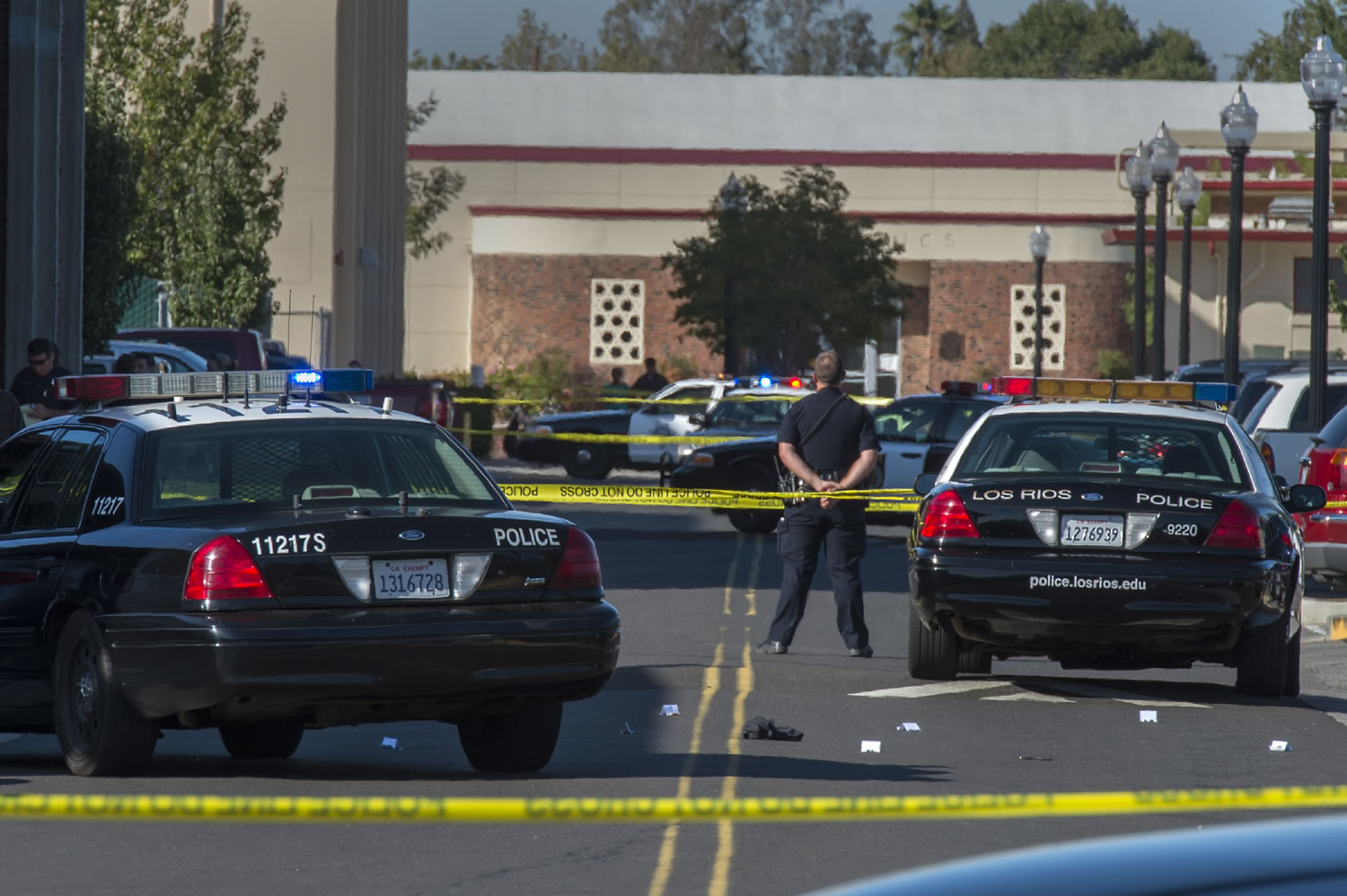 A police officer stands guard as Sacramento City College is on lockdown while police search the area after a shooting, Thursday, Sept. 3, 2015, in Sacramento, Calif. The shooting occurred in a parking lot near the baseball field on the college campus. (Ren&Egrave;e C.