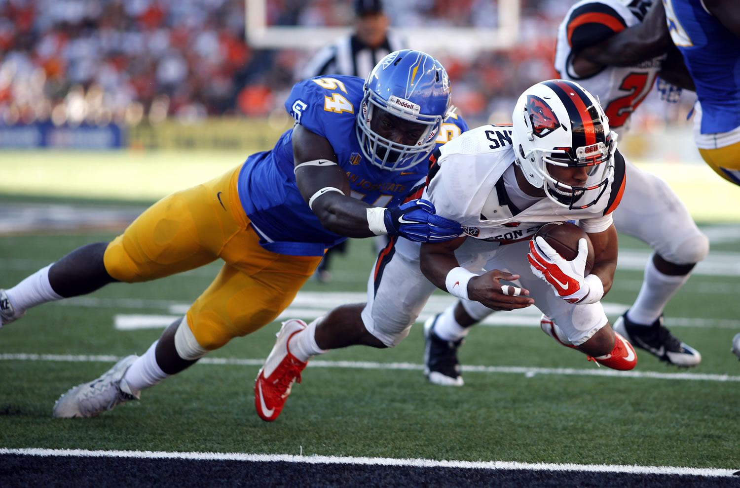 Oregon State's Seth Collins, right, dives past San Jose State's Epie Sona, left, for a touchdown during the first half in Corvallis, Ore., Saturday, Sept. 19, 2015. (AP Photo/Timothy J.