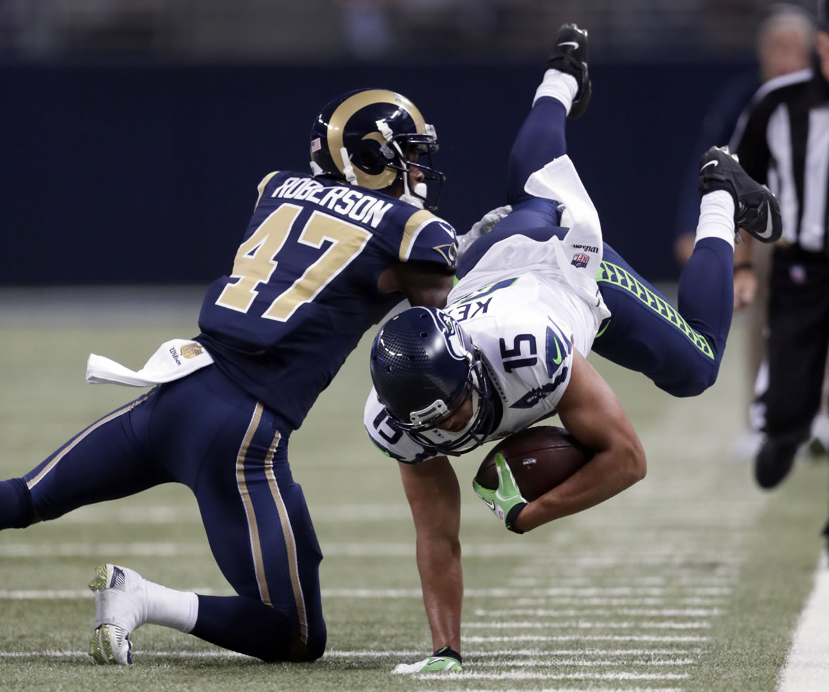 Seattle Seahawks wide receiver Jermaine Kearse, right, is stopped by St. Louis Rams cornerback Marcus Roberson after catching a pass for a 21-yard gain during the fourth quarter of an NFL football game Sunday, Sept. 13, 2015, in St. Louis.