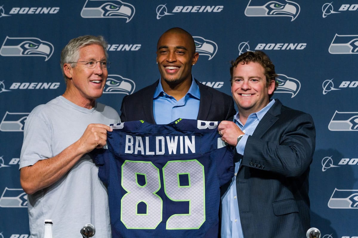 Seahawks Seahawks coach Pete Carroll, left, wide receiver Doug Baldwin, center, and general manager John Schneider for a photo with Baldwin's jersey at a news conference in Renton, Wash., on Thursday, May 29, 2014. Baldwin signed an extension that will keep him with the Seahawks through the 2016 season.