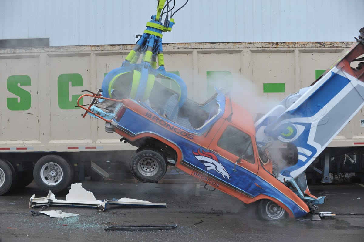 Seahawk fans at Scrap-It, a recycling business in Ferndale, destroy a 1985 Ford Bronco, painted in Denver Bronco colors Wednesday.