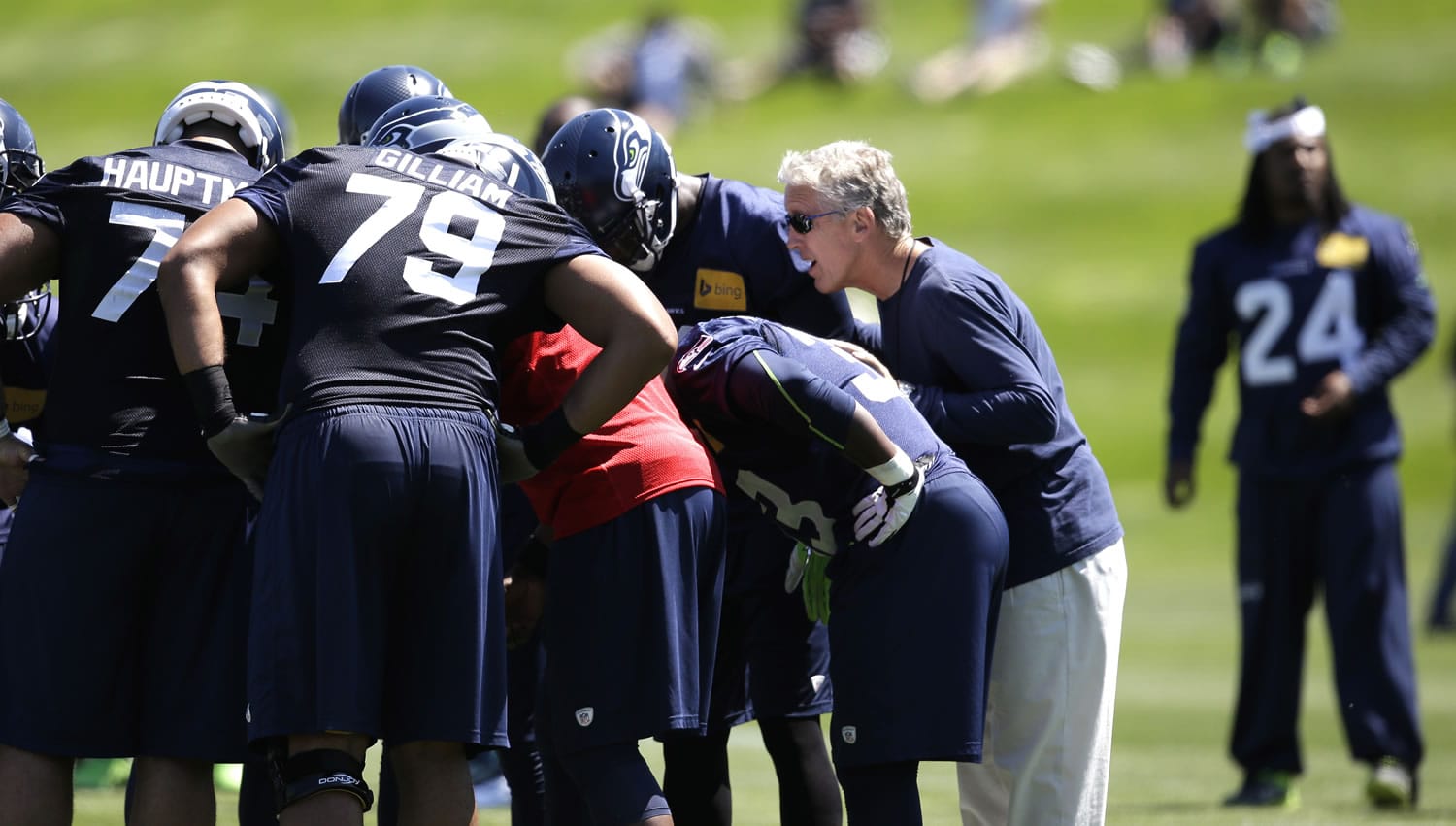 Seattle Seahawks head coach Pete Carroll listens in on a huddle during NFL football minicamp Thursday, June 19, 2014, in Renton, Wash.