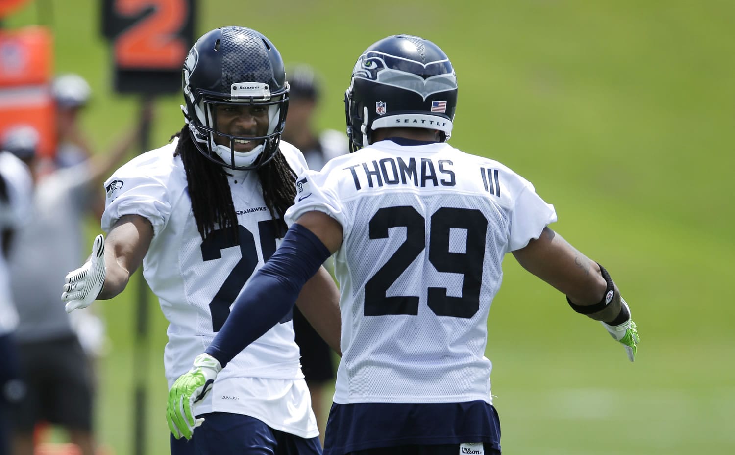 Seattle Seahawks cornerback Richard Sherman, left, reacts to a play with free safety Earl Thomas, right, during a practice drill at an NFL football organized team activity, Monday, June 9, 2014 in Renton, Wash. (AP Photo/Ted S.