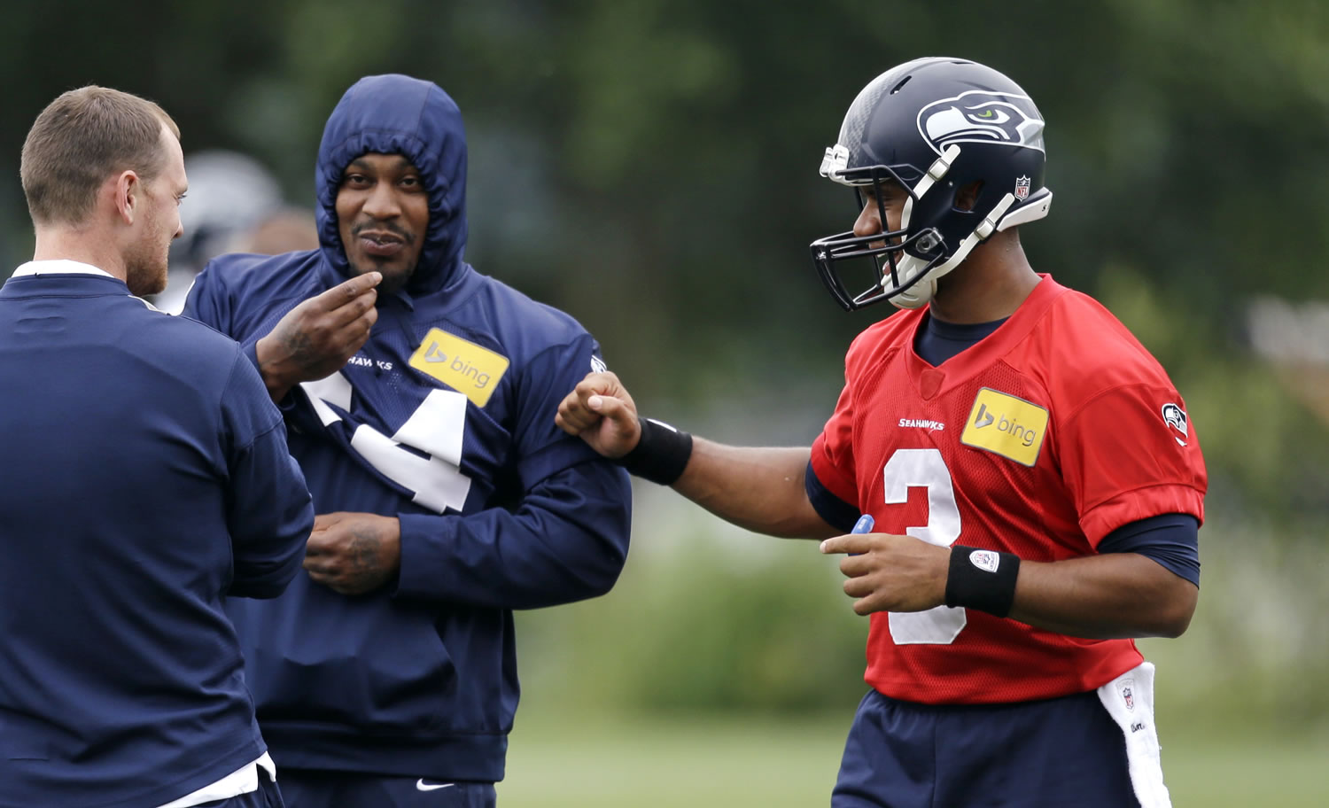 Seattle Seahawks quarterback Russell Wilson, right, greets running back Marshawn Lynch at a football minicamp practice Tuesday in Renton.