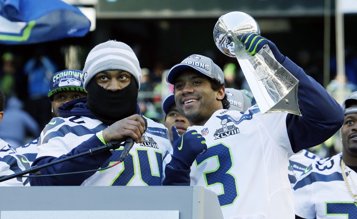 Seattle Seahawks quarterback Russell Wilson, right, lifts the Vince Lombardi Trophy next to Seahawks running back Marshawn Lynch, left, during a rally on Feb. 5.