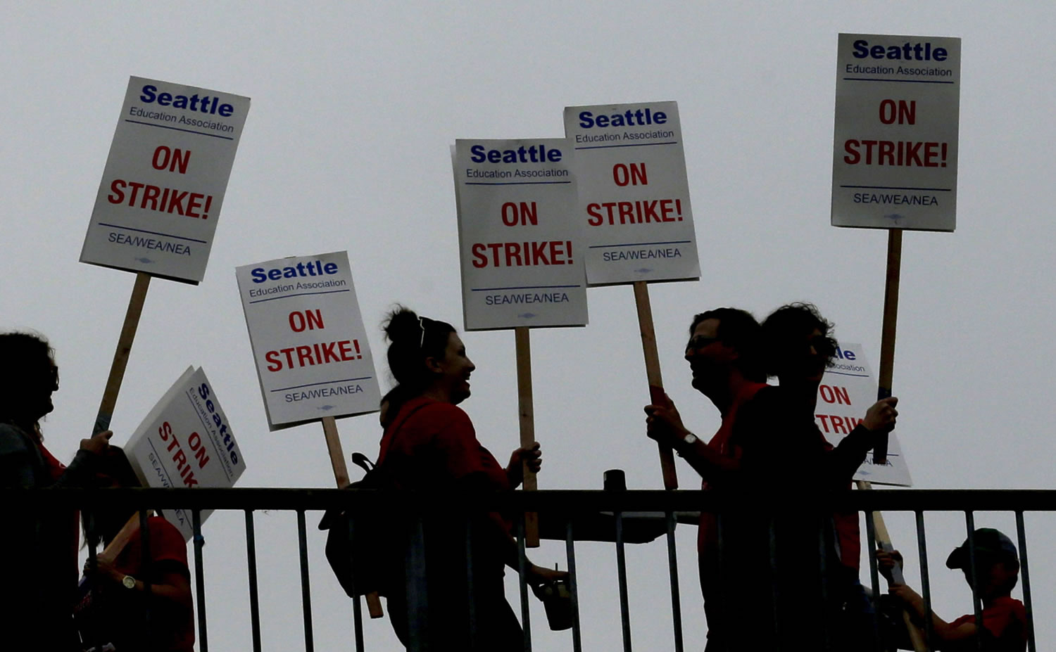 Striking Seattle School District teachers and other educators walk a picket line on a pedestrian overpass near Franklin High School in Seattle.  (AP Photo/Ted S.