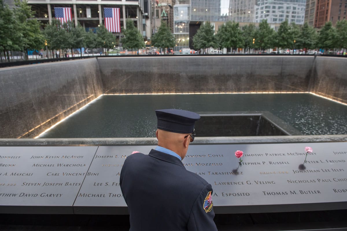 Retired New York City firefighter Joseph McCormick visits the South Pool prior to a ceremony at the World Trade Center site in New York on Friday. With a moment of silence and somber reading of names, victims' relatives began marking the 14th anniversary of Sept.