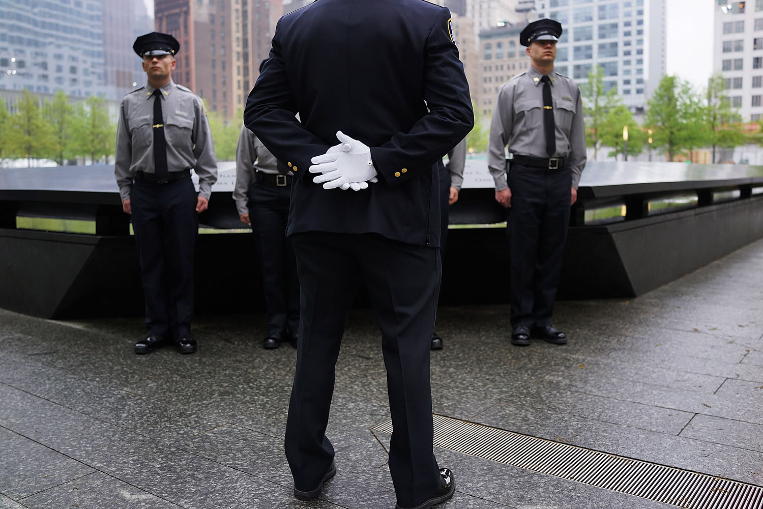 Members of the Port Authority of New York and New Jersey Police pause at the Ground Zero memorial site during the dedication ceremony of the National September 11 Memorial Museum in New York on Thursday.