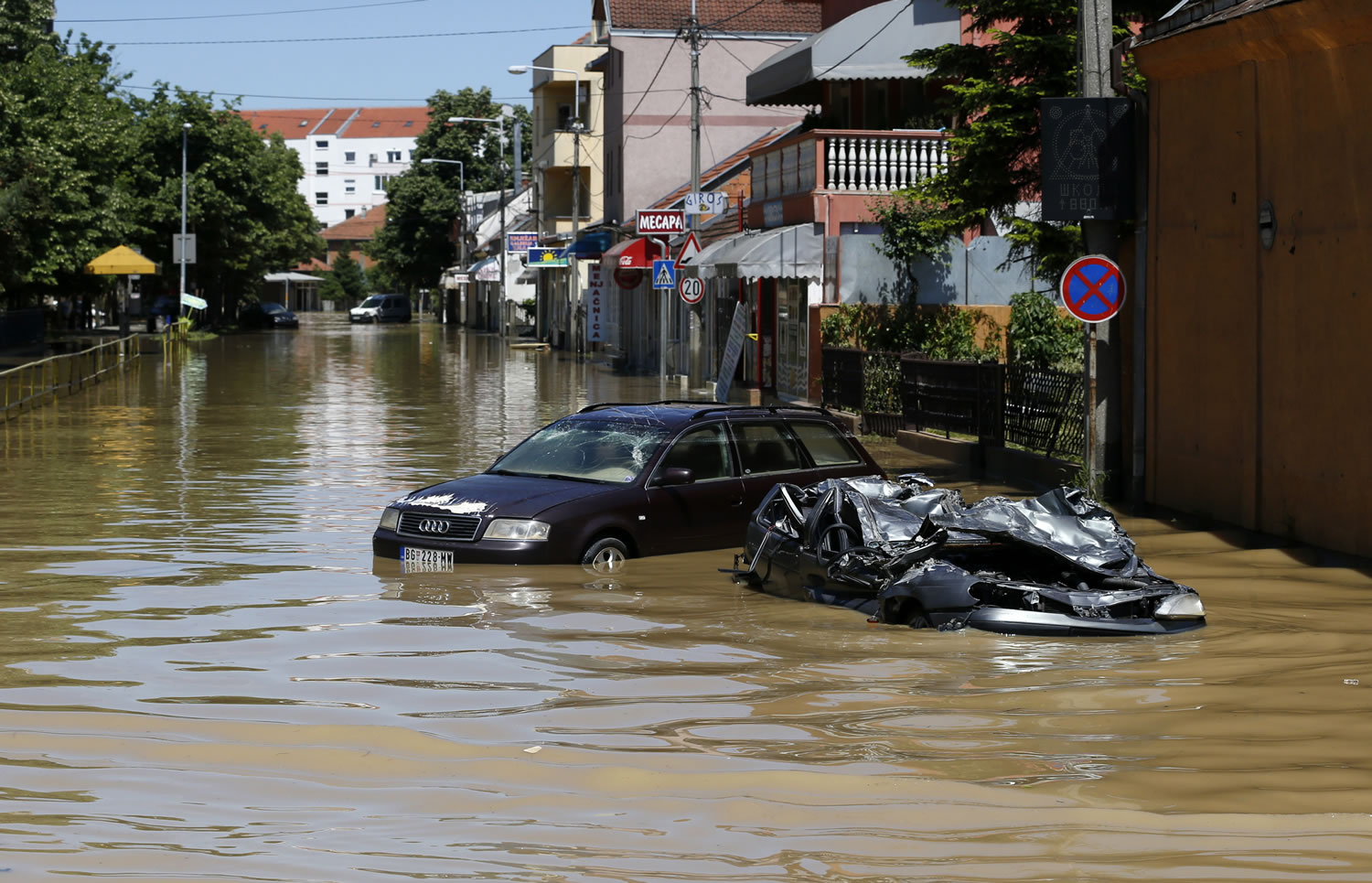 A severely damaged car  stands in a flooded street in Obrenovac, some 30 kilometers (18 miles) southwest of Belgrade, Serbia, on Monday.