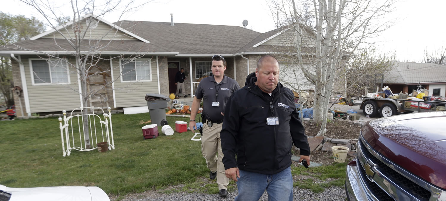Pleasant Grove Police investigate the scene Sunday where seven infant bodies were discovered and packaged in separate containers at a home in Pleasant Grove, Utah.