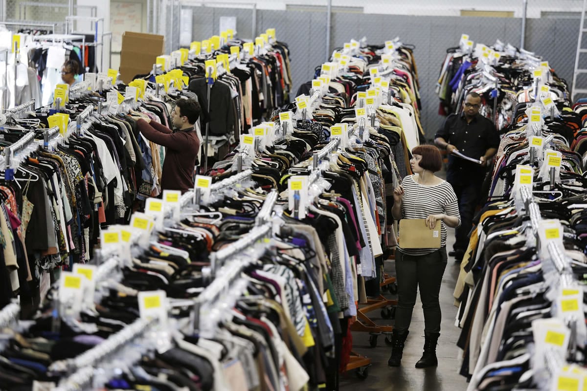 Workers locate and pull items for shipping from racks of designer clothing at the headquarters of The RealReal in San Francisco.