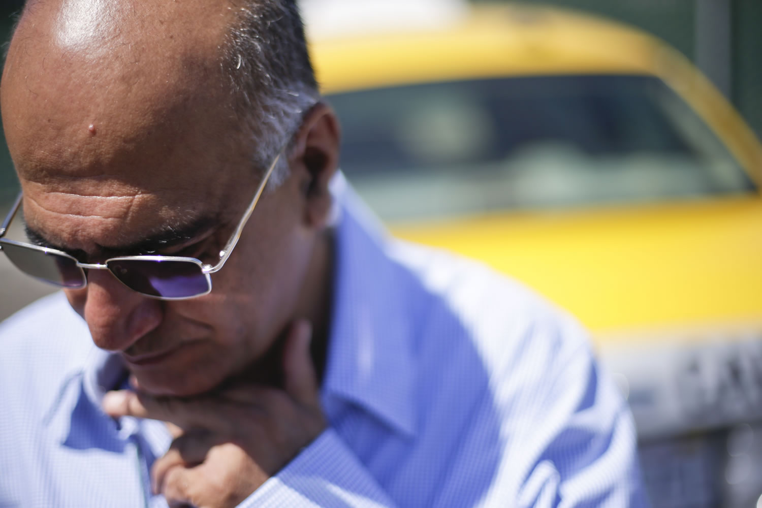 Cab driver Martin Salami looks down as he talks about new ordinances facing drivers at a depot near the airport Wednesday in San Diego.