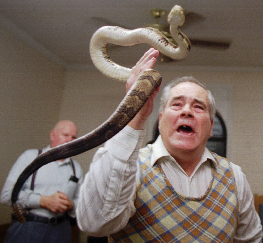 Associated Press files
Junior McCormick tests his faith by handling a rattlesnake as Homer Browing looks on in 1995 during services at the Church of the Lord Jesus in Kingston, Ga. Church members believe that if they have faith in God, they will be protected from harm as they handle the serpents.