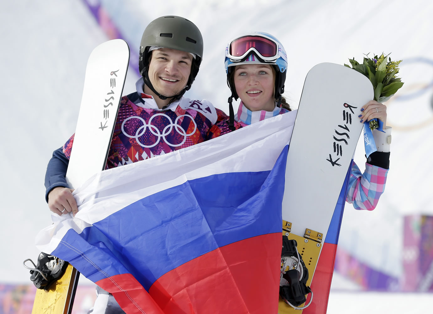 Russia's Vic Wild, left, poses after winning the gold medal in the men's snowboard parallel giant slalom final, with his wife and bronze medalist in the women's snowboard parallel giant slalom final, Russia's Alena Zavarzina.
