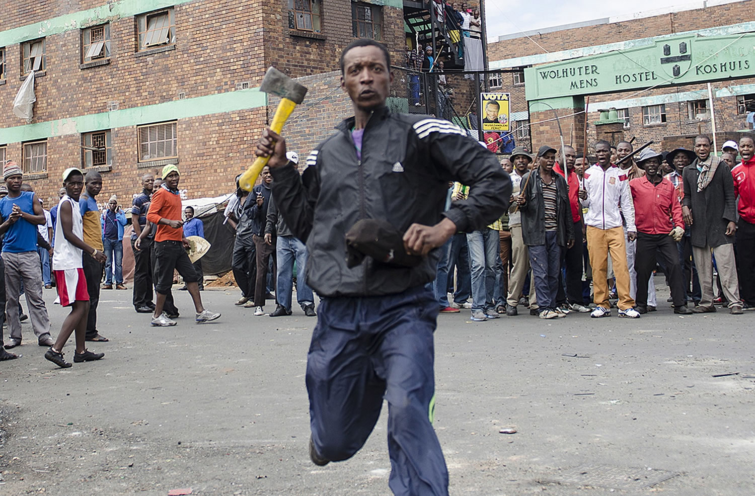 A man armed with an ax threatens members of the press Friday in Johannesburg after overnight attacks between locals and immigrants in Johannesburg. Several shops and cars were torched overnight in continued anti-immigrant attacks by locals.