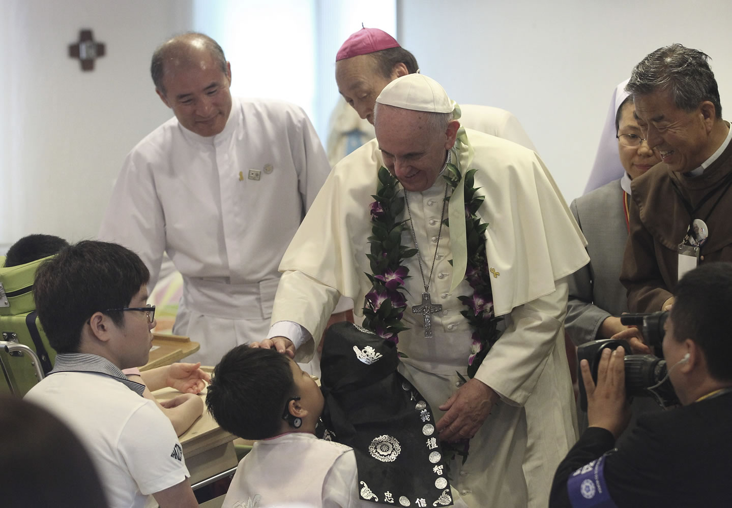 Pope Francis blesses to a disabled child during his visit to the rehabilitation center for disabled people at Kkottongnae in Eumseong, South Korea, on Saturday.