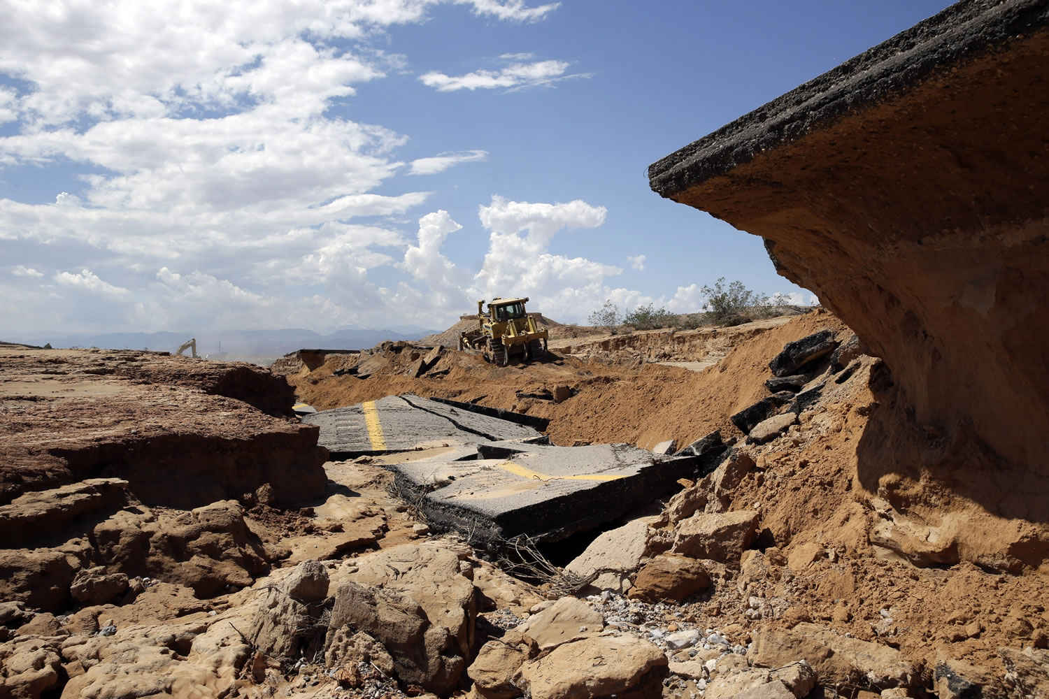 A bulldozer works on a flood-damaged section of Interstate 15 on Tuesday near Moapa, Nev.