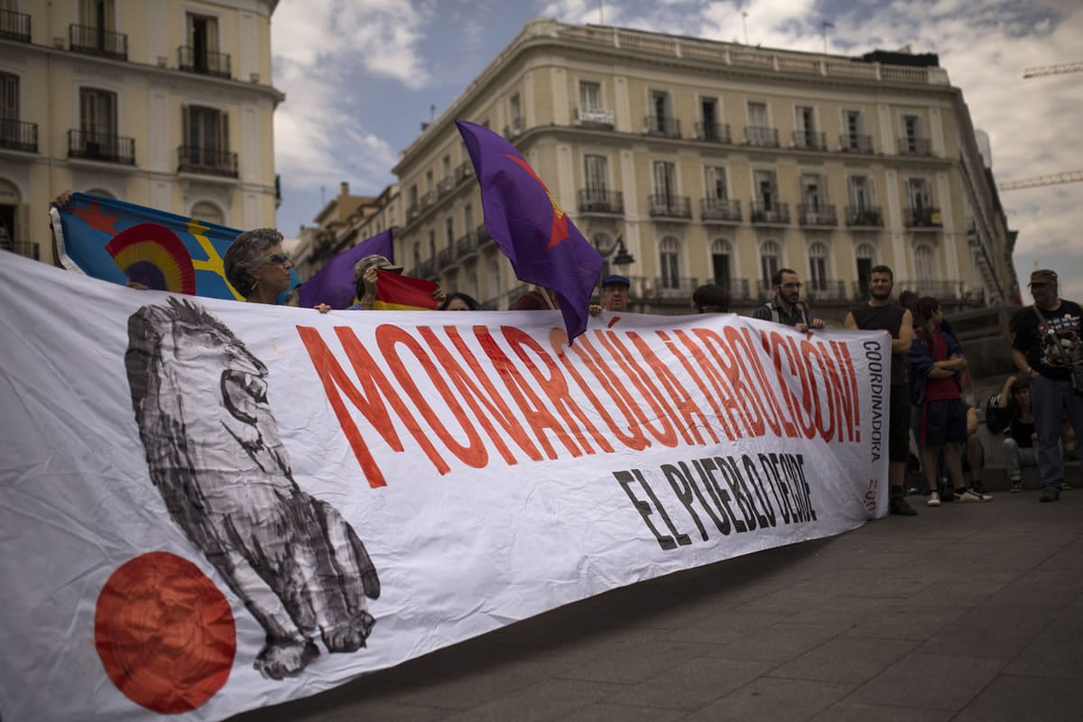 Protestors carry a banner reading &quot;Monarchy, abolition, people decide&quot; during a protest Wednesday against the monarchy near the parliament in Madrid, Spain.