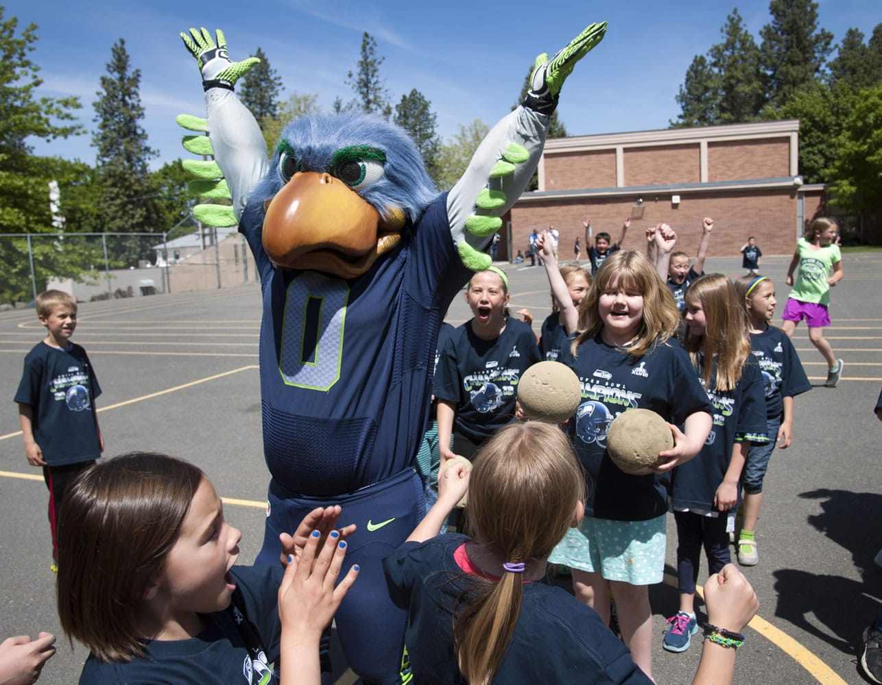 Seattle Seahawks mascot Blitz celebrates with students on the Wilson Elementary School playground after sinking a three-quarter-length court shot during recess Thursday in Spokane.