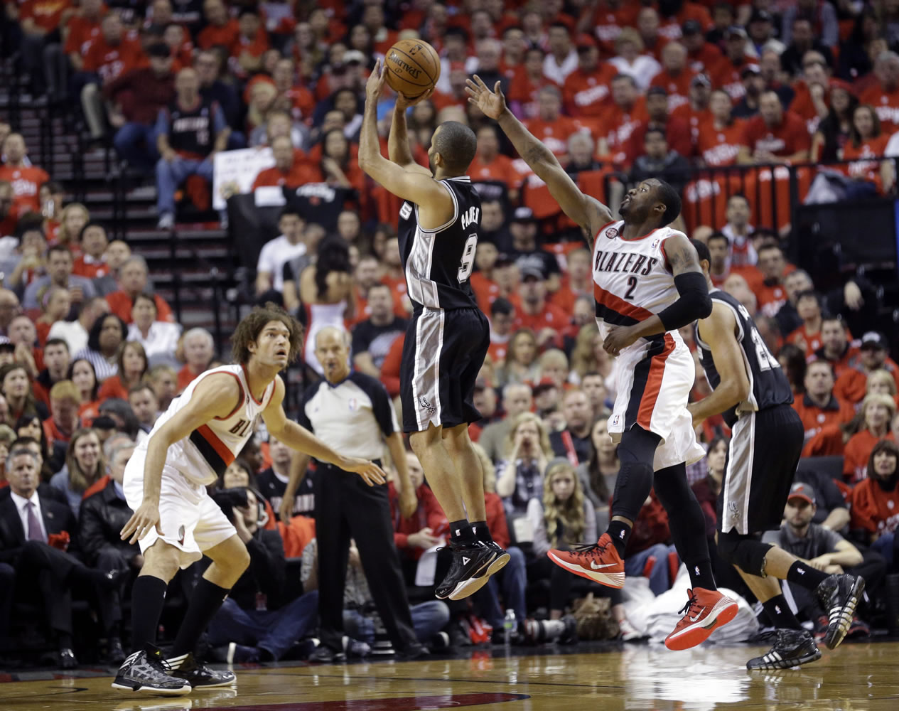 San Antonio Spurs' Tony Parker (9) shoots as Portland Trail Blazers' Robin Lopez (42) and Wesley Matthews (2) defend in the first quarter of Game 3 on Saturday.