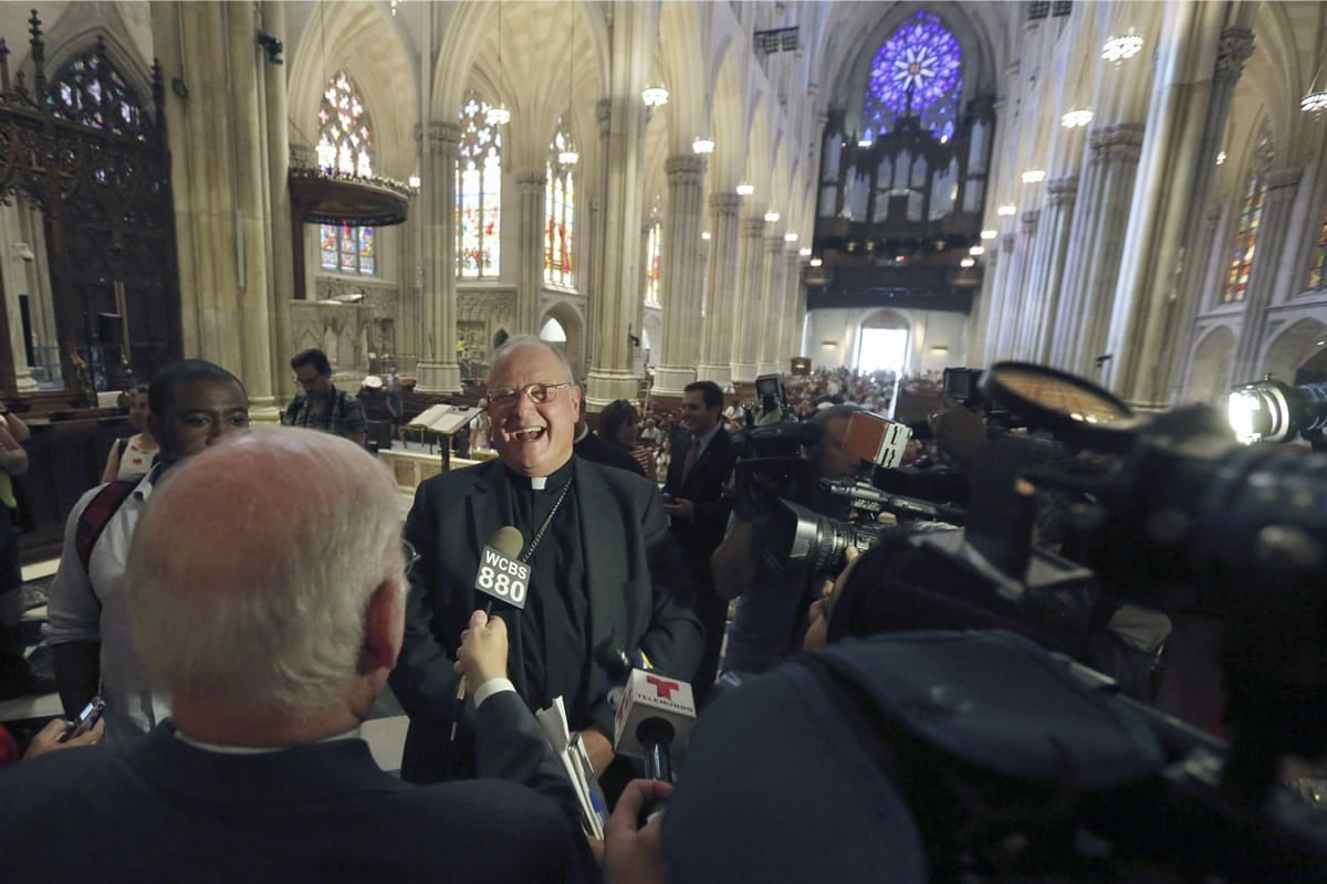 Timothy Cardinal Dolan, Archbishop of New York, speaks to reporters after a ceremony in which galeros, or cardinal's hats, were once again hung from the cathedral ceiling Aug. 25 at St. Patrick's Cathedral in New York. The renovation, done in three phases over three years, started in 2012 and is slated to be finished before the Pope's visit in September 2015.